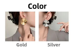 Macro detail of large round textured earrings in gold and silver mirror finishes