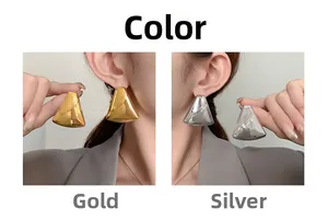 Detailed view of geometric triangle earrings in gold and silver with grooved textures