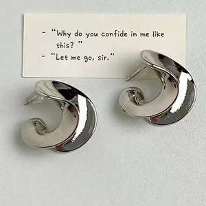 Artistic twisted silver plated stud earrings with high mirror finish on a clean background