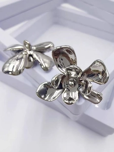 Macro view of S925 sterling silver floral earrings with polished five-petal flower detail