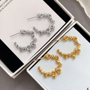 Dettaglio di orecchini stile lava in metallo argento e oro in scatole per gioielli