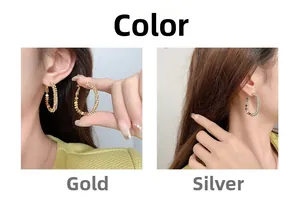 Détail de créoles texturées dorées et argentées avec motif à pois sur le modèle d'oreille