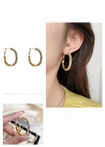 Détail de créoles dorées avec micro-pavage de cristaux et accents de paillettes