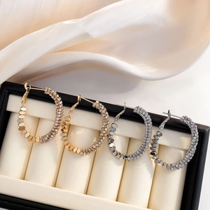 Boucles d'oreilles créoles dorées et argentées avec zircons dans un écrin de luxe
