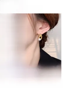 Detail of tulip-shaped earrings with gold plating and white pearls in French luxury style