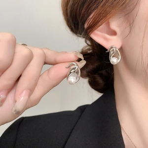 Silver-plated organic leaf earrings with white pearls shown on a model