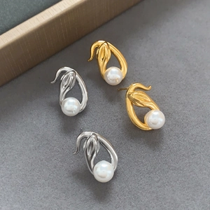 Streamlined snake-shaped pearl stud earrings in polished gold and silver finishes