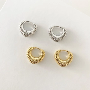 Golden and silver hollow croissant hoop earrings with a textured ribbed metal design