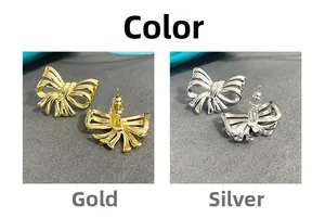 Detail view of bow earrings in gold and silver finish with polished metal texture