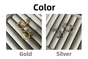 Detail of gold and silver plated earrings with hammered metal texture in a jewelry box