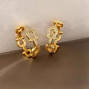 Detail of gold-plated hoop earrings featuring micro-pave white crystals in a link design
