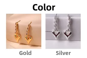 Detail view of gold and silver heart earrings with marquise-cut marquise-cut zircon accents