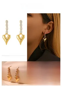 Detail view of heart-shaped gold-plated earrings with pave-set baguette cubic zirconia