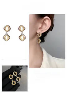 Detail of geometric rhombus earrings featuring gold hammered texture and silver outer frame