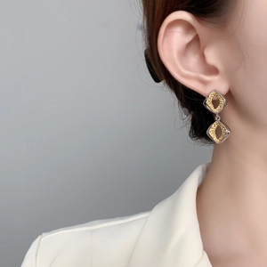 Fashion silver and gold geometric diamond-shaped dangle earrings on model