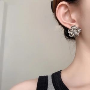 Boucles d'oreilles fleurs argentées en métal avec pétales 3D plissés sur l'oreille