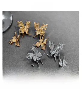 Detailed close-up of gold and silver butterfly stud earrings with textured wing patterns