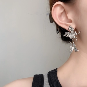 Detail shot of silver double butterfly stud earrings on a model showing elegant metallic finish
