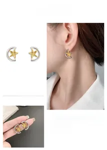 Detailed view of silver crescent moon and golden hammered star stud earrings on model