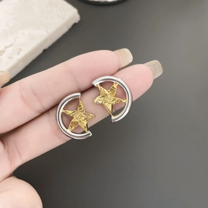 Close-up of gold star and silver crescent earrings with hand-hammered texture detail