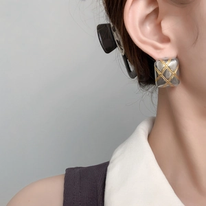 Close-up of square quilted stud earrings in two-tone gold and silver finish