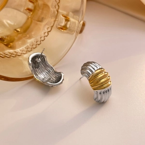 Detail of two-tone gold and silver croissant earrings with ribbed spiral texture