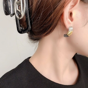 Two-tone gold and silver striped ribbed hoop earrings with a modern geometric design