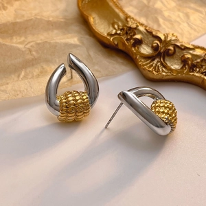 Detailed close-up of S925 sterling silver stamp on two-tone gold and silver earrings