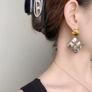 Minimalist geometric diamond drop earrings with gold and silver metallic texture