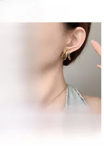 Detailed views of geometric gold and silver two-tone V-shaped earrings for women