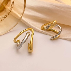Minimalist twisted gold and silver mixed metal stud earrings with S-curve design