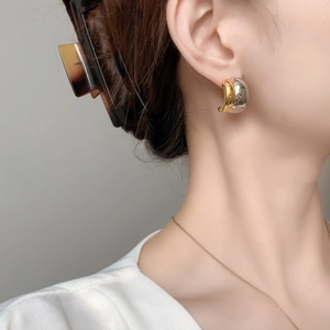 Minimalist C-shaped two-tone gold and silver earrings on model with high mirror finish