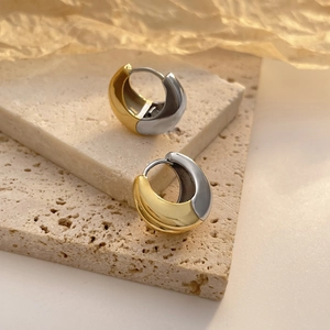 Orecchini a cerchio bicolore oro e argento in stile chunky su una base di pietra grezza