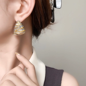 Minimalist irregular triangle stud earrings with textured gold and silver finish on model
