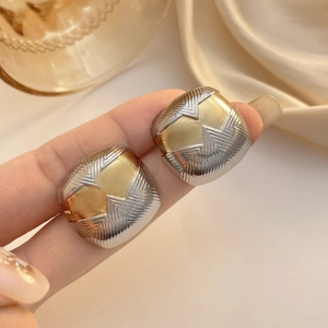 Détail macro des boucles d'oreilles carrées bicolores avec finition en métal texturé vintage