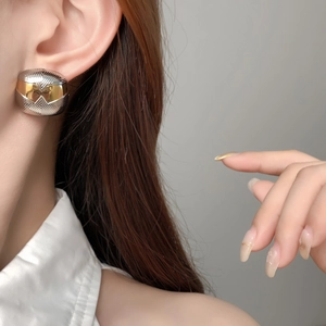 Boucles d'oreilles géométriques bicolores or et argent portées par un mannequin