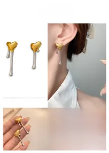 Detail of mixed-tone gold and silver heart earrings with liquid metal texture design