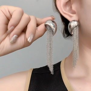 Detail of long silver tassel earrings with polished hemisphere and fine chain fringe