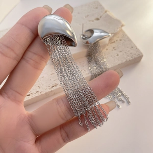 Detailed view of silver long chain tassel earrings with teardrop stud and polished finish
