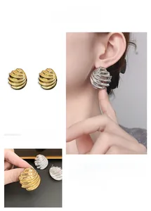 Macro detail of wave textured shell style gold plated stud earrings for women