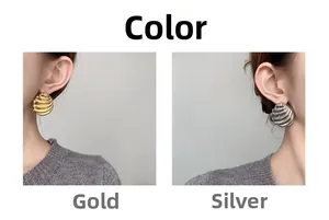 Detail view of wave pattern shell earrings in gold and silver finish on model