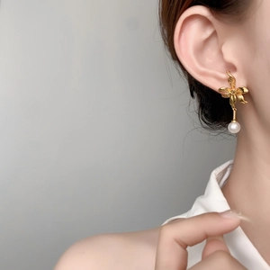 Elegant gold flower earrings with white pearl pendants and detailed metallic petals