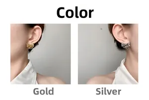 Detail view of gold and silver hollow bow earrings on model with vertical striped texture