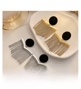 Detail shot of long chain tassel earrings with black studs in gold and silver plating