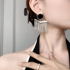 Detail of bohemian tassel earrings with black gemstones and silver crystal fringes