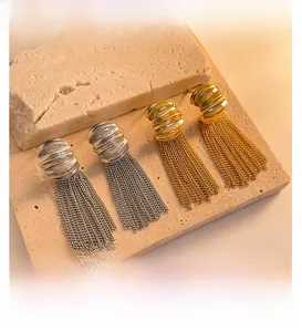 Detail of layered gold and silver chain fringe earrings on natural stone props