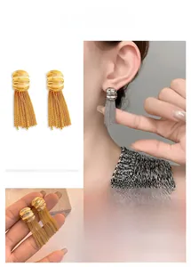 Detail of layered gold and silver chain fringe earrings with textured studs