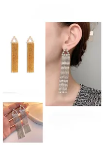 Gros plan de boucles d'oreilles à pampilles longues avec triangles en zircon en or et argent