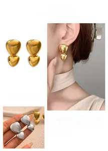 Detail of high-polish heart stud earrings in gold and silver showing liquid metal texture