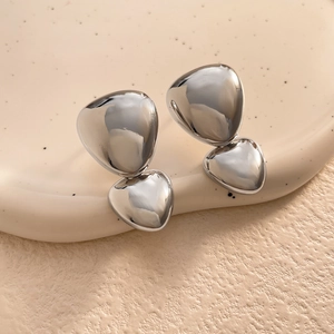 Macro view of mirror-polished silver-plated irregular pebble-shaped stud earrings
